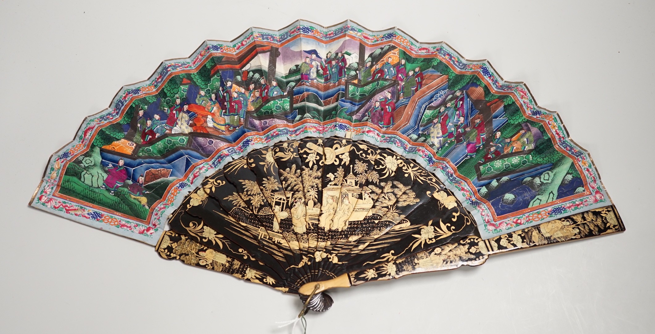 A 19th century Chinese painted paper leaf and lacquer painted fan in a gilt decorated black lacquer fitted case, the fan with painted ivory appliqué faces, 28cm